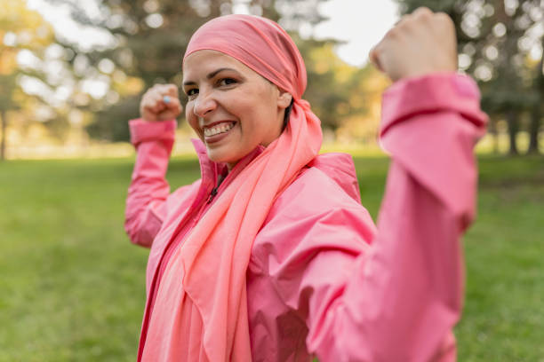 Young woman cancer suvivor in flexing pose dressed in pink